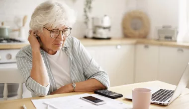 Femme âgée préoccupée par finances à domicile.