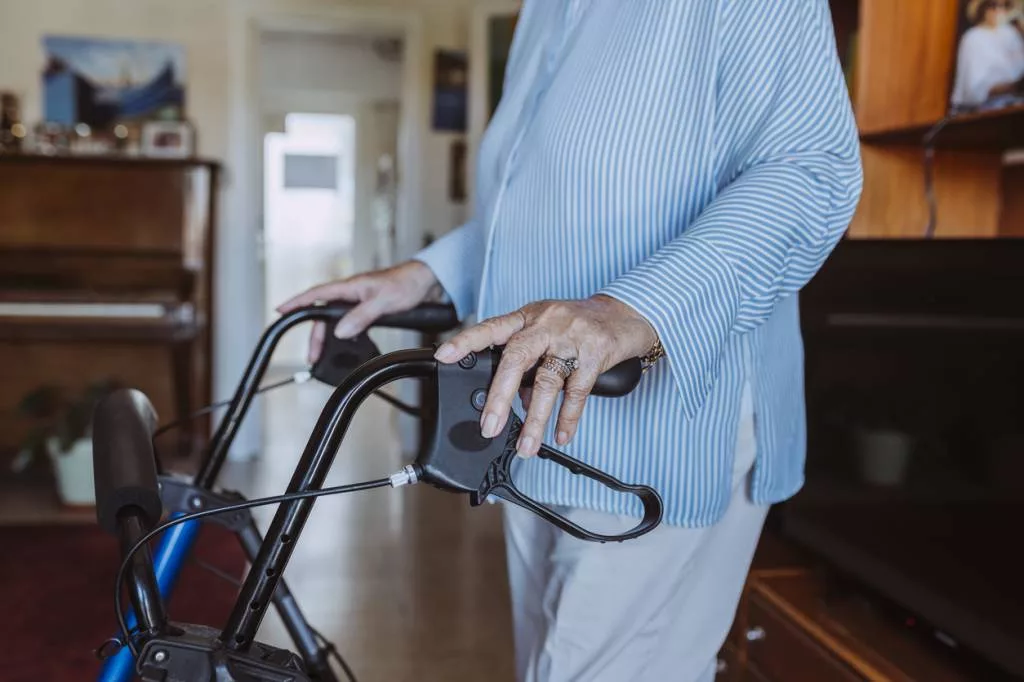 Personne âgée utilisant un déambulateur à la maison.