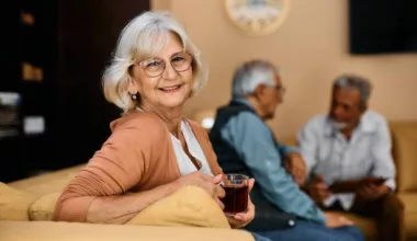 Femme âgée souriante avec une tasse de thé.