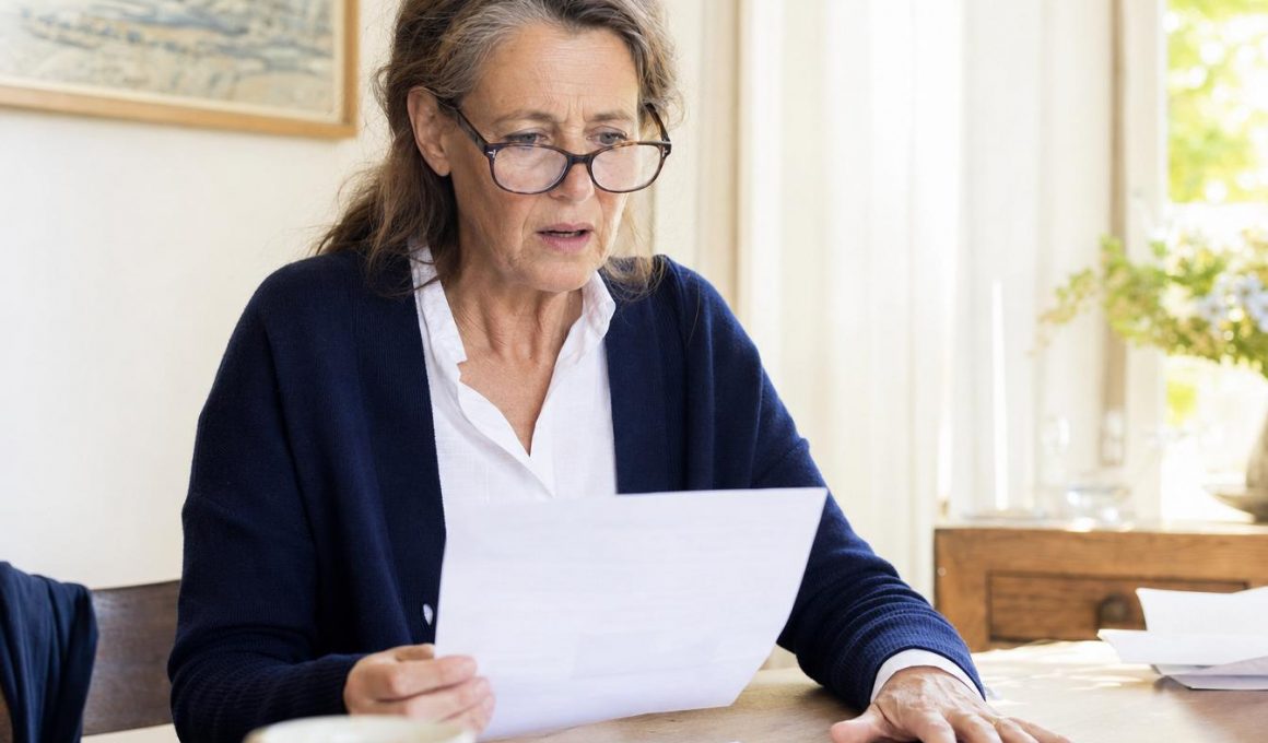 Femme âgée lisant un document avec inquiétude