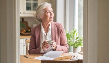 Femme senior tenant une tasse à table