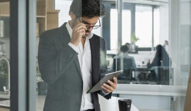 Homme en costume consultant une tablette au bureau