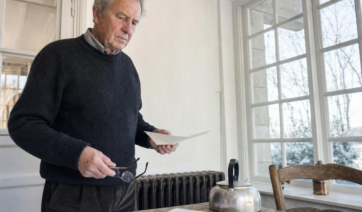 Homme âgé lisant une lettre près d’une fenêtre