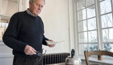 Homme âgé lisant une lettre près d’une fenêtre